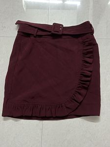 burgundy ruffled mini skirt with a belt.