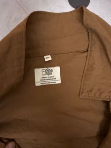 brown fitted shirt with a belt like strand behind