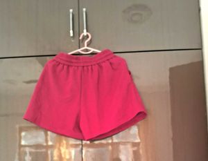 A pair of fuchsia shorts with  drawstring waist