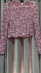 Cropped top in soft fabric with a round neckline, long sleeves and overlocked edges at the cuffs and hem.