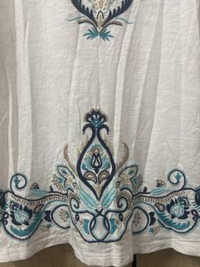 Blue Embroidery On A White Tunic