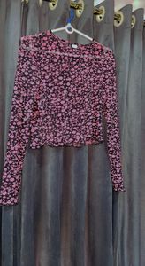 Cropped top in soft fabric with a round neckline, long sleeves and overlocked edges at the cuffs and hem.