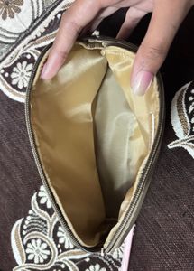 This is a taupe faux leather makeup bag
