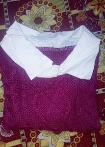 cable-knit sweater vest layered over a white colla