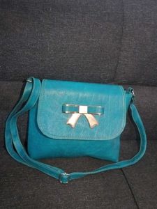 BLUE SLING BAG WITH ADJUSTABLE STRAP.