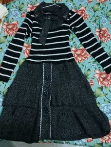 This is a black and white striped sweater dress wi