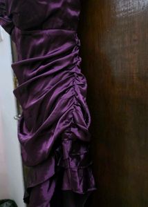 Purple ruffle dress with tailing on left side.