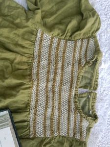 An olive-green kids&#39; top with puff sleeves