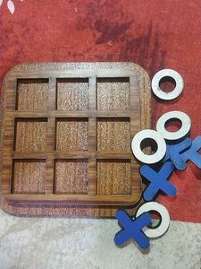 a wooden tic tak toe game board with 8 pieces