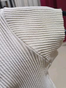 white ribbed cropped top with a charm