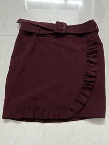 burgundy ruffled mini skirt with a belt.