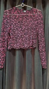 Cropped top in soft fabric with a round neckline, long sleeves and overlocked edges at the cuffs and hem.