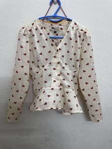long-sleeved peplum blouse in an off-white