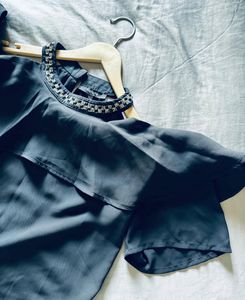 women’s black blouse featuring short sleeves, a so