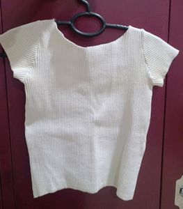 white ribbed cropped top with a charm