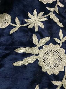 A navy blue ethenic skirt with shiny material .