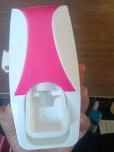 Toothpaste dispenser with toothbrush holder