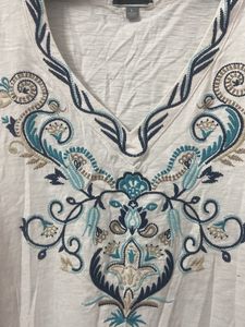 Blue Embroidery On A White Tunic