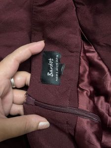 burgundy ruffled mini skirt with a belt.