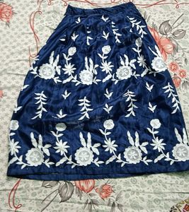 A navy blue ethenic skirt with shiny material .