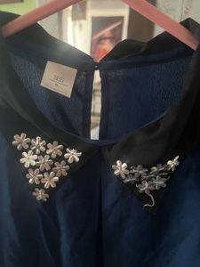 Elegant navy blouse with floral-embellished collar