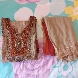 Heavy Designer Party Wear Golden Silk Printed Kurti With Churidar Net Sleeves , Full Lining And Velvet Border . Heavy Zardozi Embroidery On Front . Shaded Chiffon Dupatta With Gota. No Bottom.