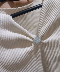 white ribbed cropped top with a charm