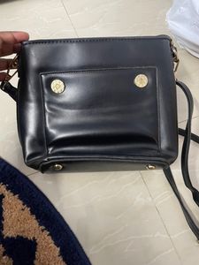 Black Sling Bag From Ajio. This Sling Is Sturdy and Useful For Keeping A Small Purse Along With Two Phones And Other Small Items. Bag Has 5 Compartments.