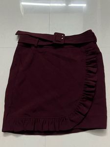 burgundy ruffled mini skirt with a belt.