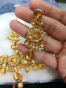 A Diamond Necklace Set With Earnings And Mangtika
