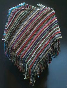 a colorful, striped poncho-style shawl with fringe