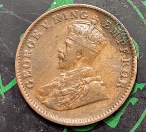 “1936” British India one-quarter Anna coin.