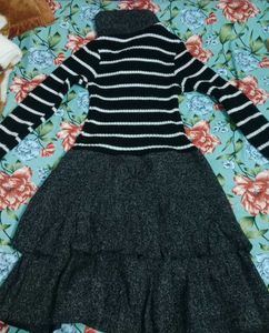 This is a black and white striped sweater dress wi