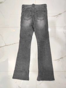 A lightly washed charcoal grey boot cut jeans