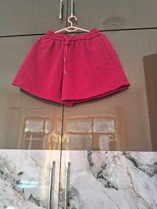 A pair of fuchsia shorts with  drawstring waist