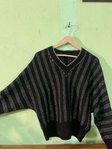 black V-neck sweater with wide, dolman-style sleev