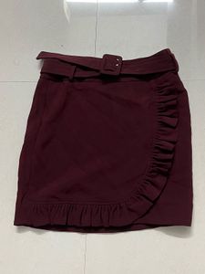 burgundy ruffled mini skirt with a belt.