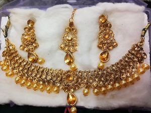 A Diamond Necklace Set With Earnings And Mangtika