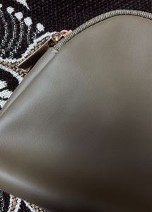 This is a taupe faux leather makeup bag