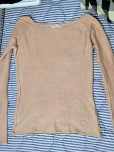 light beige or nude-colored long-sleeve top