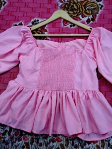 pink puff-sleeve peplum top with a ruched front an