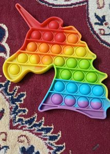 A rainbow-colored unicorn-shaped pop-it fidget toy