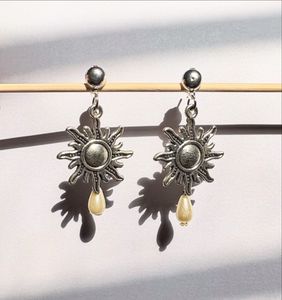 Metal sun with a pearl drop earring