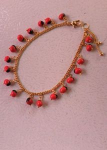 GOLD CHAIN BRACELET WITH RED & BLACK CHARMS