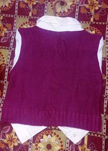 cable-knit sweater vest layered over a white colla