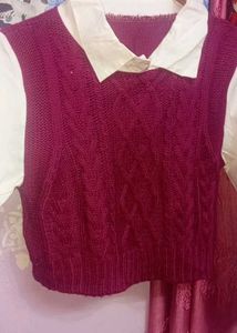 cable-knit sweater vest layered over a white colla