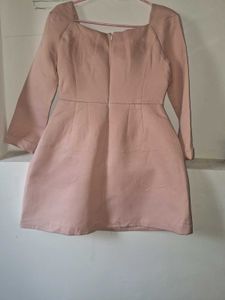 A long-sleeved pink top and embroidered blue jeans