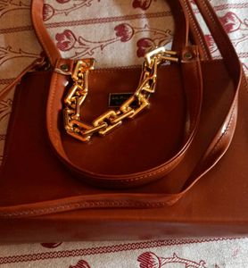 Brown Bag With A Chain Attached To It