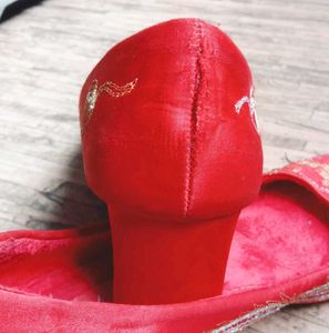 A pair of red, embroidered flat shoes..