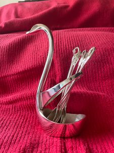 Product: Swan desert spoon stand. Material: Nickle